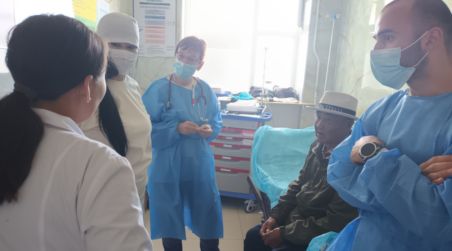 un ambulatorio in Mongolia: nell'immagine è presente un paziente seduto e quattro medici e infermiere che si confrontano